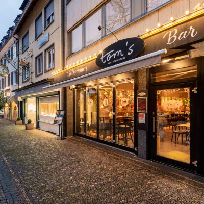 Straßenansicht vom hell beleuchteten Restaurant-Eingang